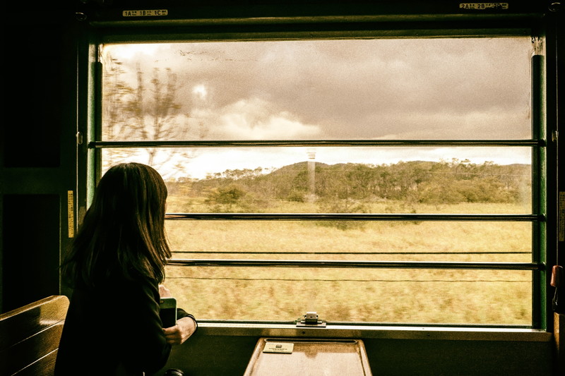 女性が車窓から風景を眺めている